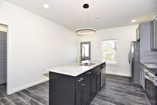 kitchen featuring sink, hanging light fixtures, a kitchen island with sink, light stone countertops, and stainless steel appliances