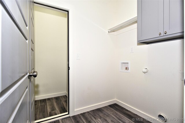 clothes washing area featuring dark wood-type flooring, cabinets, and washer hookup