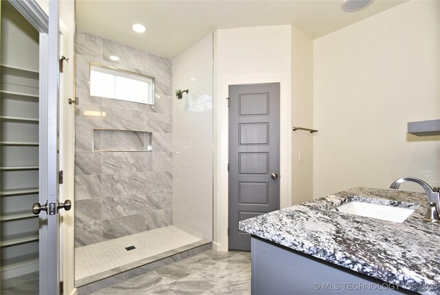 bathroom with vanity and tiled shower