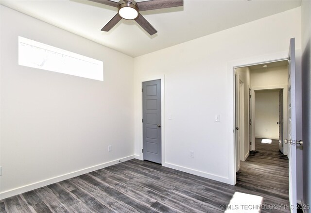 unfurnished bedroom featuring ceiling fan and dark wood-type flooring