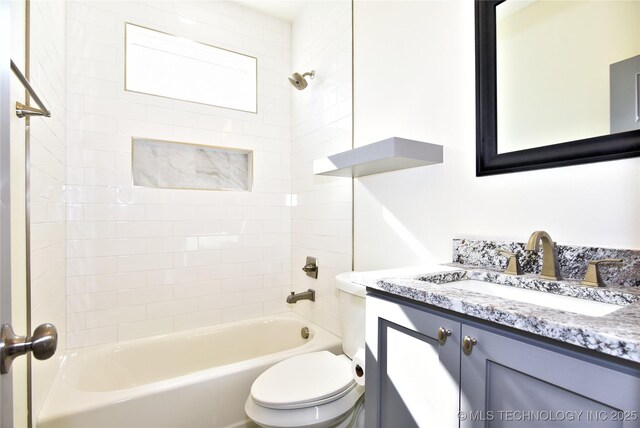 full bathroom featuring toilet, tiled shower / bath, and vanity