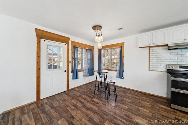 unfurnished dining area with dark wood-type flooring