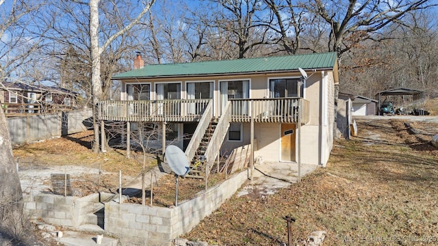 view of front facade with a garage, a deck, and an outdoor structure