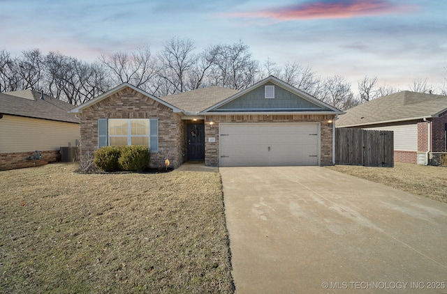 view of front of property with central AC unit, a garage, and a yard