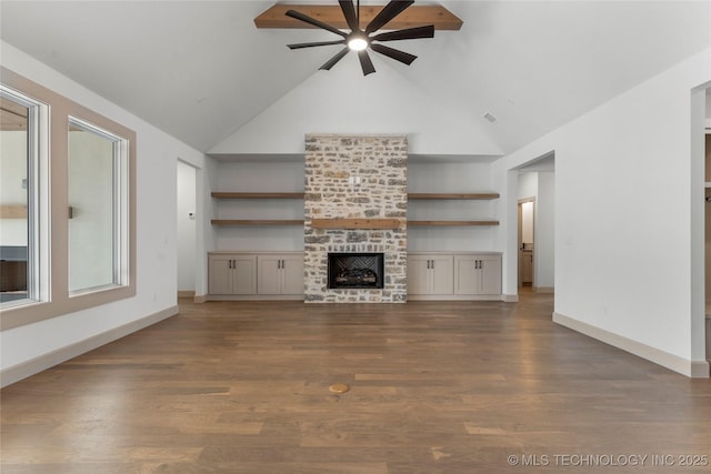 unfurnished living room with dark wood-style flooring, visible vents, a large fireplace, high vaulted ceiling, and baseboards