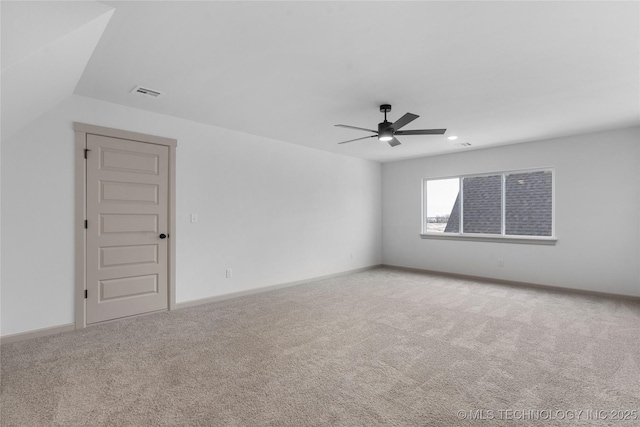 carpeted spare room with ceiling fan, visible vents, and baseboards