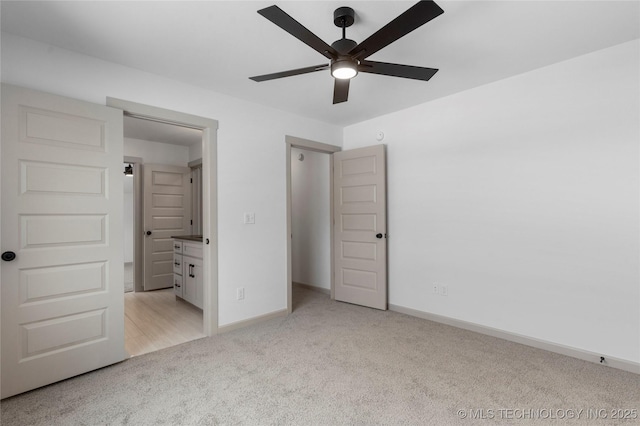 unfurnished bedroom with baseboards, a ceiling fan, and light colored carpet