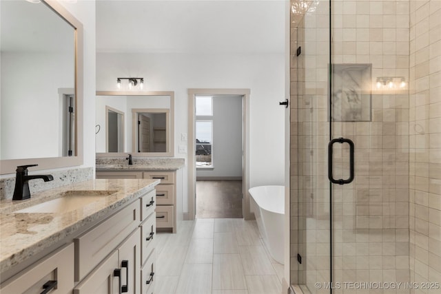 bathroom featuring a stall shower, a freestanding tub, and vanity