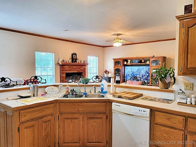 kitchen featuring kitchen peninsula, a fireplace, dishwasher, ornamental molding, and sink