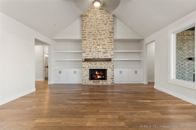 unfurnished living room featuring hardwood / wood-style floors, a fireplace, built in features, and high vaulted ceiling