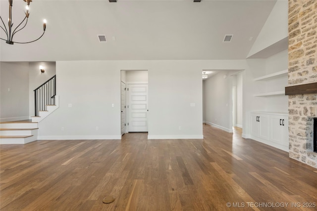 unfurnished living room featuring a notable chandelier, a fireplace, high vaulted ceiling, and wood-type flooring