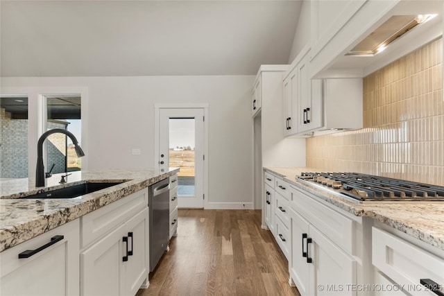 kitchen with appliances with stainless steel finishes, light stone countertops, sink, and white cabinets