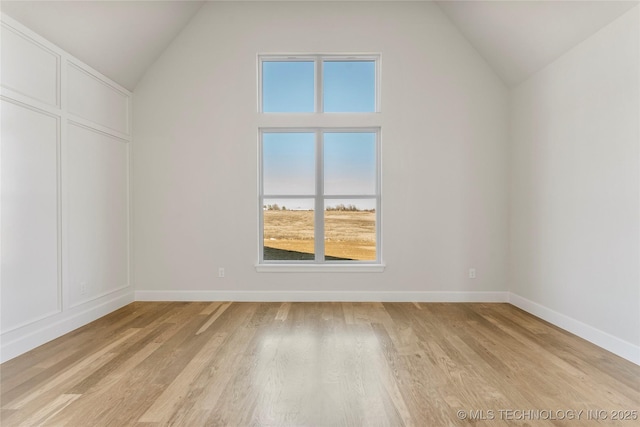 additional living space featuring lofted ceiling and light hardwood / wood-style flooring