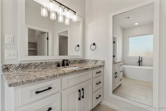 bathroom with a tub to relax in and vanity