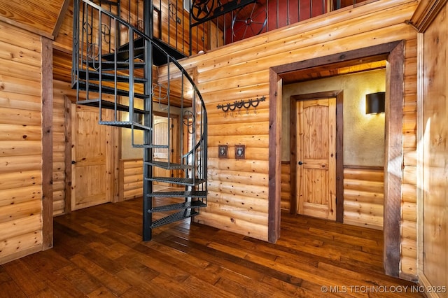 staircase with hardwood / wood-style floors and rustic walls