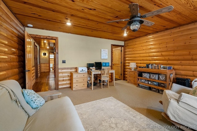 carpeted home office with ceiling fan, radiator heating unit, wooden ceiling, and rustic walls