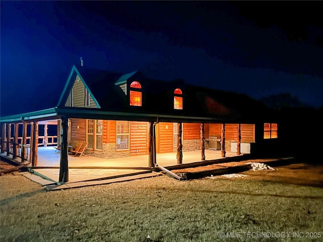 back house at night featuring a patio