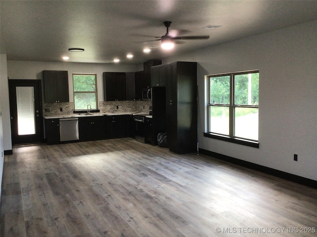 kitchen with ceiling fan, backsplash, sink, light hardwood / wood-style flooring, and appliances with stainless steel finishes