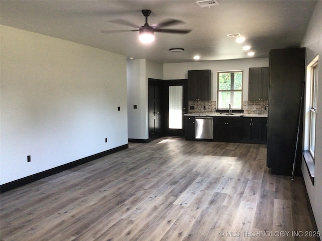 kitchen featuring ceiling fan, tasteful backsplash, light wood-type flooring, dishwasher, and sink