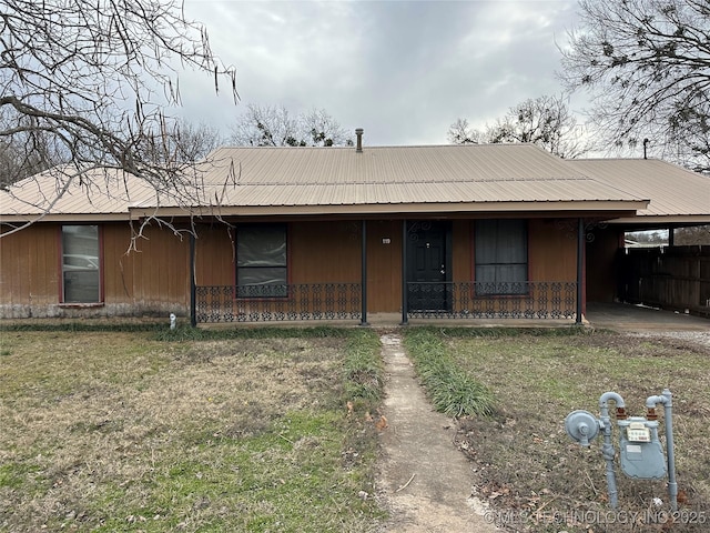 119 S Arkansas St, Caddo, OK 74729 - view of front of house with metal roof, a front yard, a porch, and an attached carport