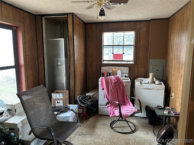 119 S Arkansas St, Caddo, OK 74729 - misc room with electric panel, wood walls, a textured ceiling, and concrete floors