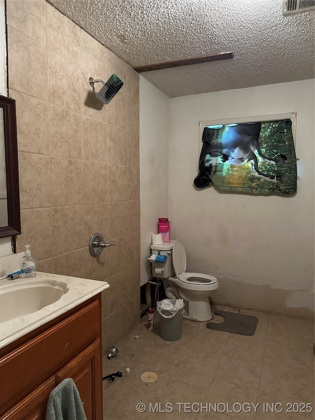 119 S Arkansas St, Caddo, OK 74729 - bathroom featuring toilet, a textured ceiling, visible vents, walk in shower, and vanity
