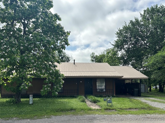 119 S Arkansas St, Caddo, OK 74729 - ranch-style home featuring metal roof, driveway, a front yard, and a carport