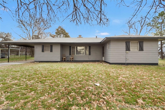 back of property with a yard and a carport