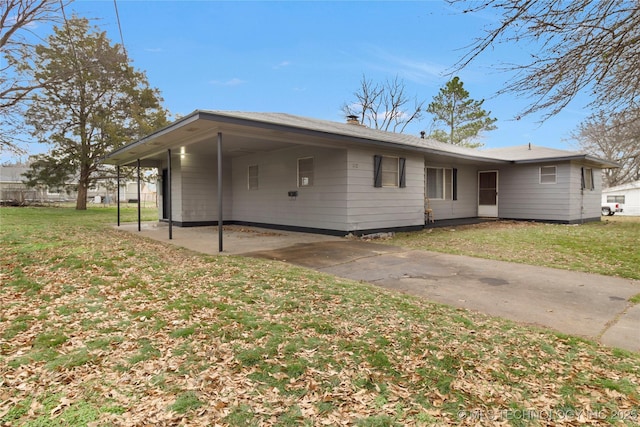 rear view of house featuring a lawn and a carport