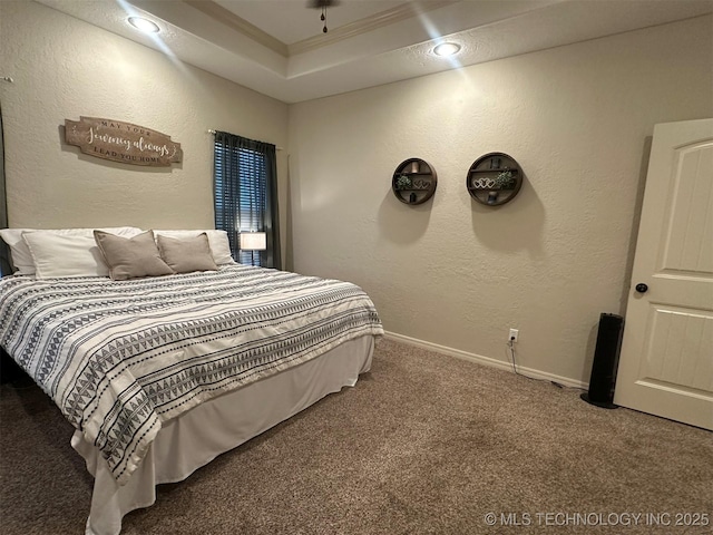 carpeted bedroom featuring a raised ceiling and ornamental molding