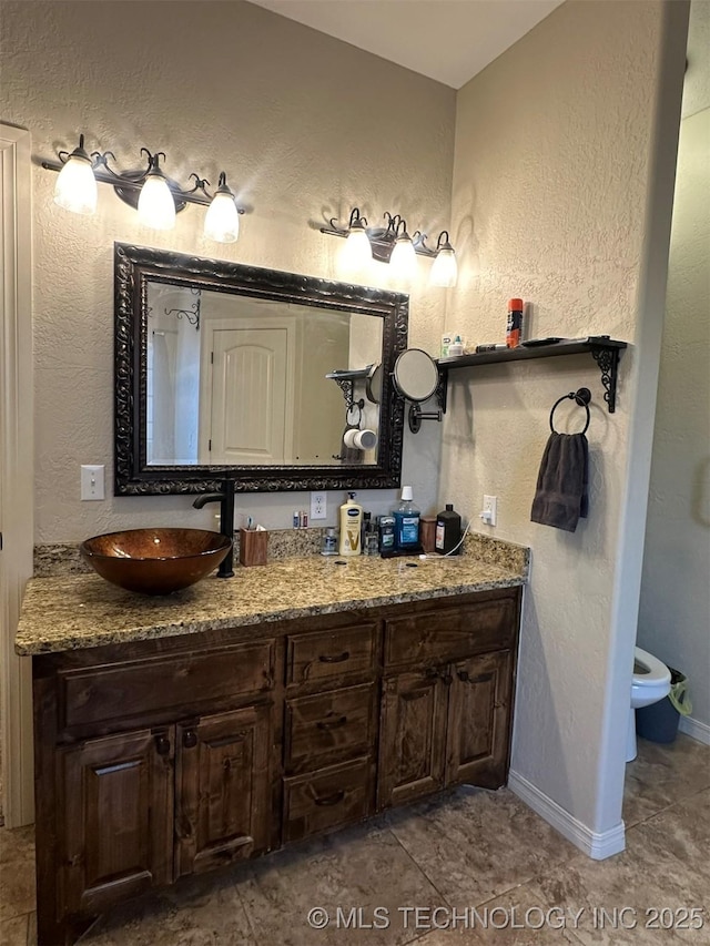 bathroom featuring toilet, vanity, and tile patterned floors