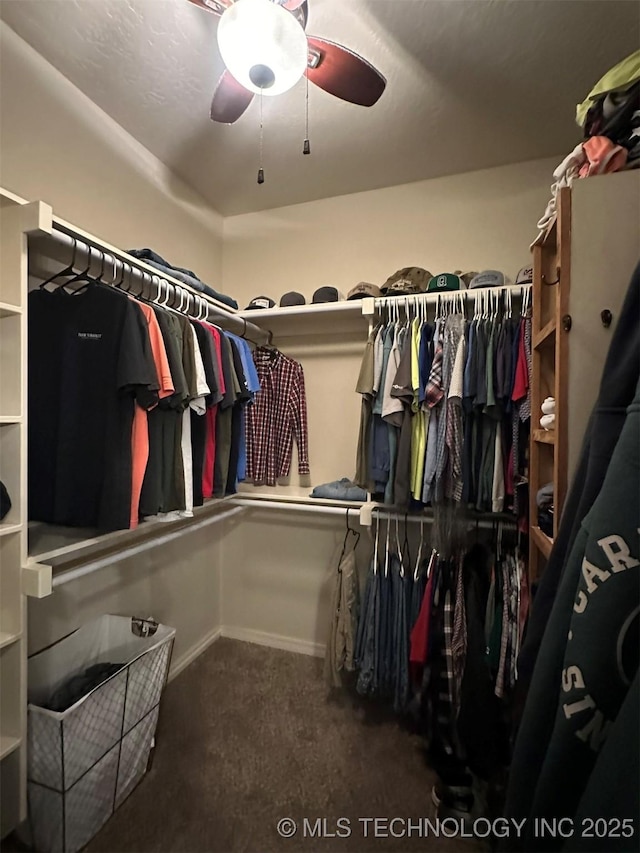 walk in closet with ceiling fan and dark carpet