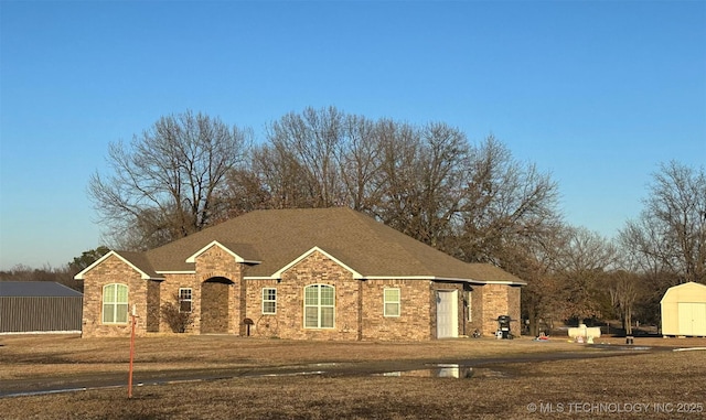 view of front facade featuring a front lawn and a storage unit