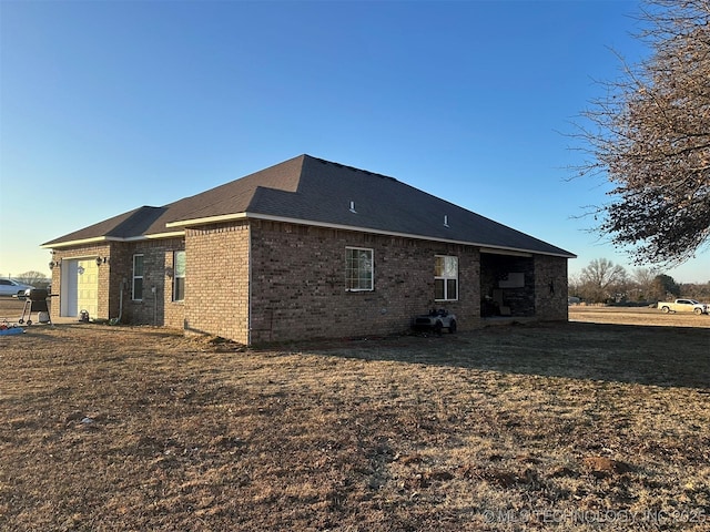 rear view of house with a lawn and a garage