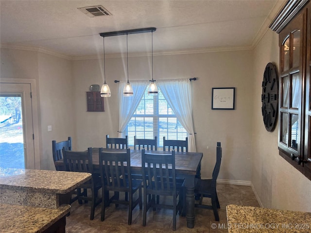 dining area with a textured ceiling and ornamental molding