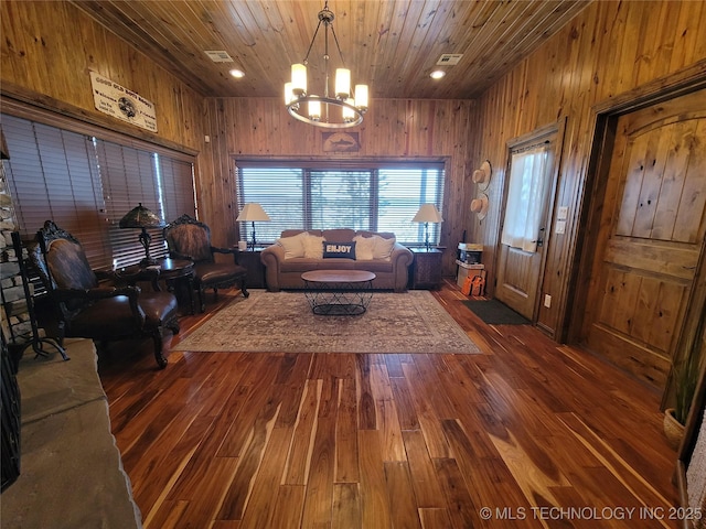 unfurnished living room featuring wood walls, a notable chandelier, wood ceiling, and dark hardwood / wood-style flooring