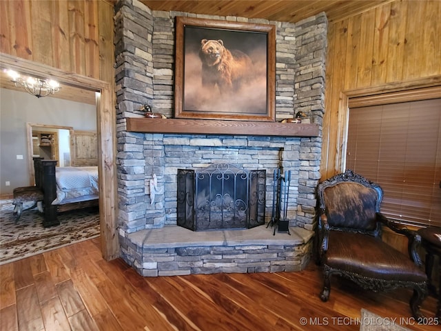 interior space with wood-type flooring, a fireplace, wood ceiling, and wood walls