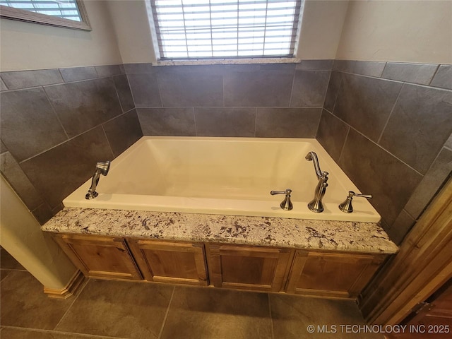 bathroom featuring tile patterned floors and a tub to relax in