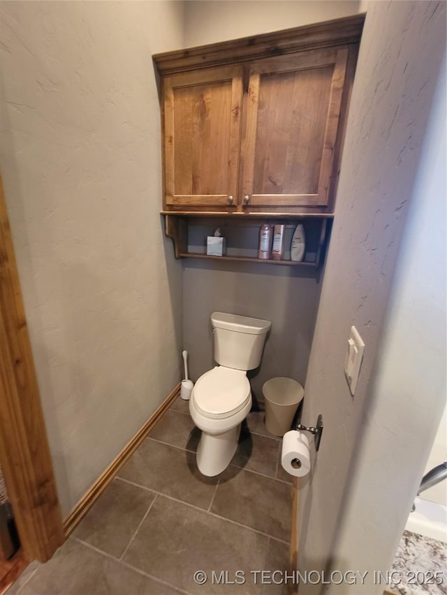 bathroom featuring toilet and tile patterned flooring