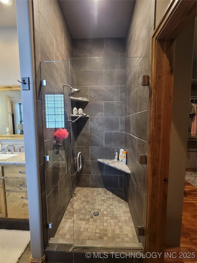 bathroom with an enclosed shower, vanity, and hardwood / wood-style floors