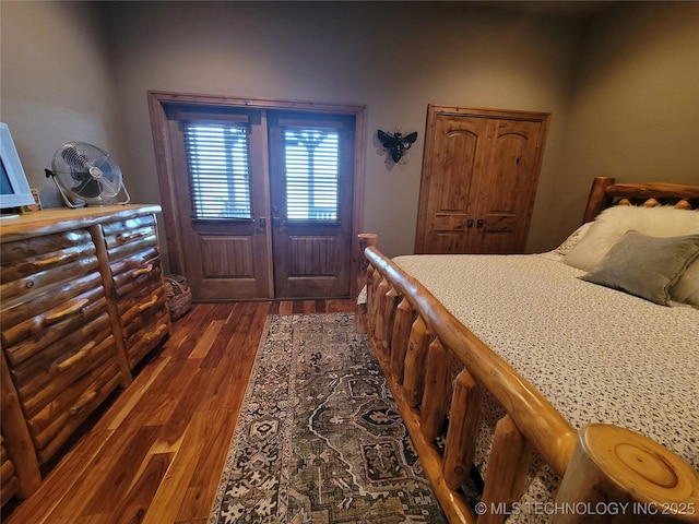 bedroom with french doors and dark hardwood / wood-style floors