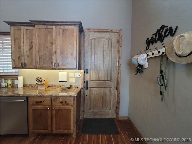 kitchen featuring stainless steel dishwasher and dark wood-type flooring