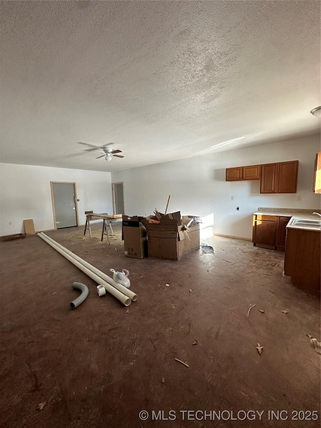 misc room with ceiling fan, sink, and a textured ceiling