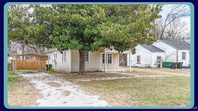 view of front of home with a front yard, cooling unit, and a carport