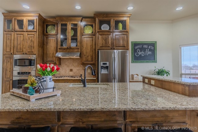 kitchen with appliances with stainless steel finishes, ornamental molding, and sink