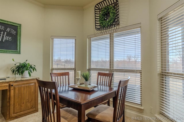 tiled dining area featuring crown molding