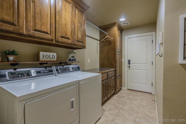 washroom with washer and clothes dryer and cabinets