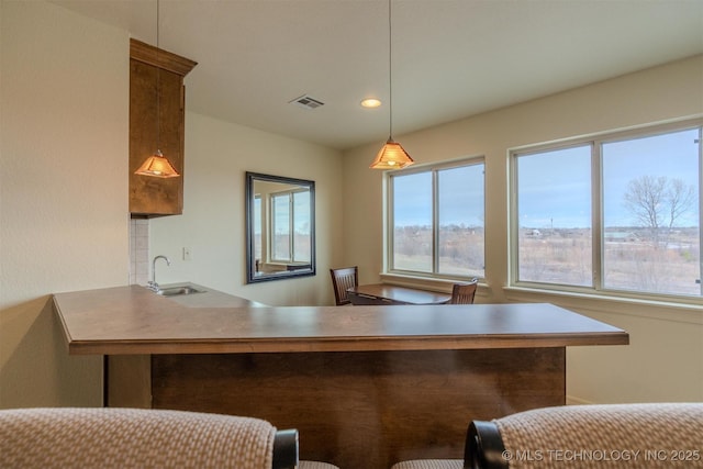 kitchen with sink, pendant lighting, and kitchen peninsula