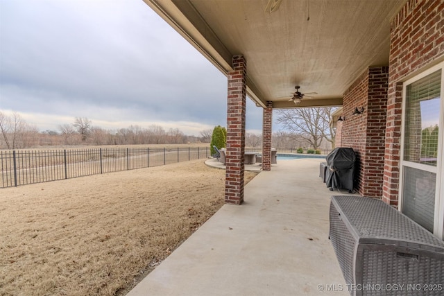 view of patio with ceiling fan, a rural view, a grill, and a fenced in pool