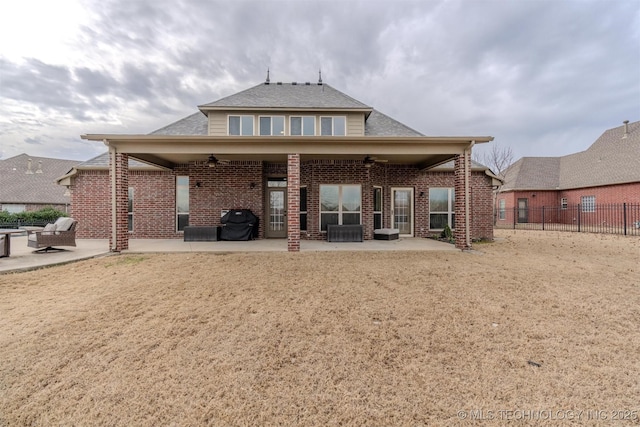 back of property with ceiling fan and a patio